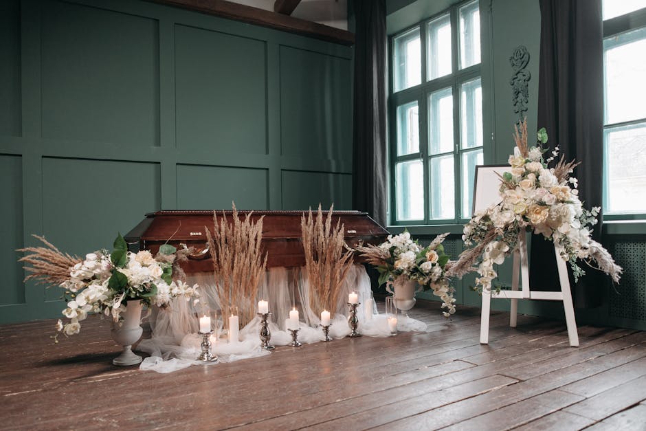 An elegant floral arrangement featuring white orchids, pale pink roses, and cream-colored lilies, complemented by dried pampas grass in beige and light brown, arranged in white ceramic vases placed on